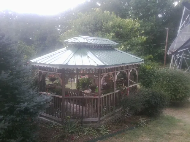 Green metal roof on a backyard gazebo surrounded by garden beds in Sorrento